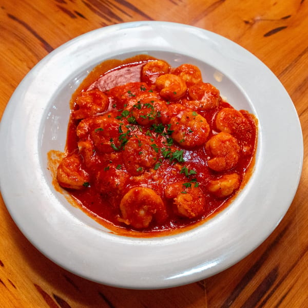 Big Daddy's NY BBQ shrimp in a rich red sauce, garnished with fresh parsley.