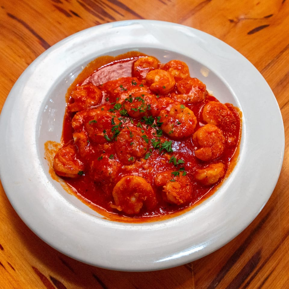 Big Daddy's NY BBQ shrimp in a rich red sauce, garnished with fresh parsley.